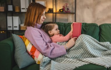 Mother and daughter toddler girl read book at home
