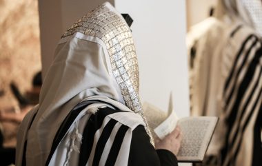 Jewish,orthodox,man,wrapped,in,prayer,shawl,from,a,side