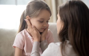 Loving,young,mother,touching,upset,little,daughter,face,,expressing,support,