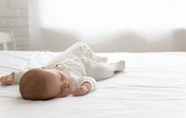 Sleepy,silent,few,month,infant,resting,in,double,bed,with
