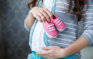 Small,shoes,for,the,unborn,baby,in,the,belly,of