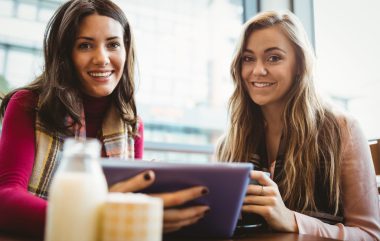 Friends,using,tablet,together,in,cafe