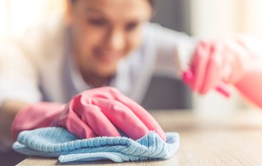 Woman,In,Protective,Gloves,Is,Smiling,And,Wiping,Dust,Using