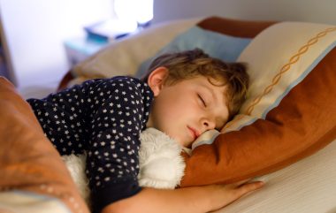 Little,Preschool,Kid,Boy,Sleeping,In,Bed,With,Colorful,Lamp.