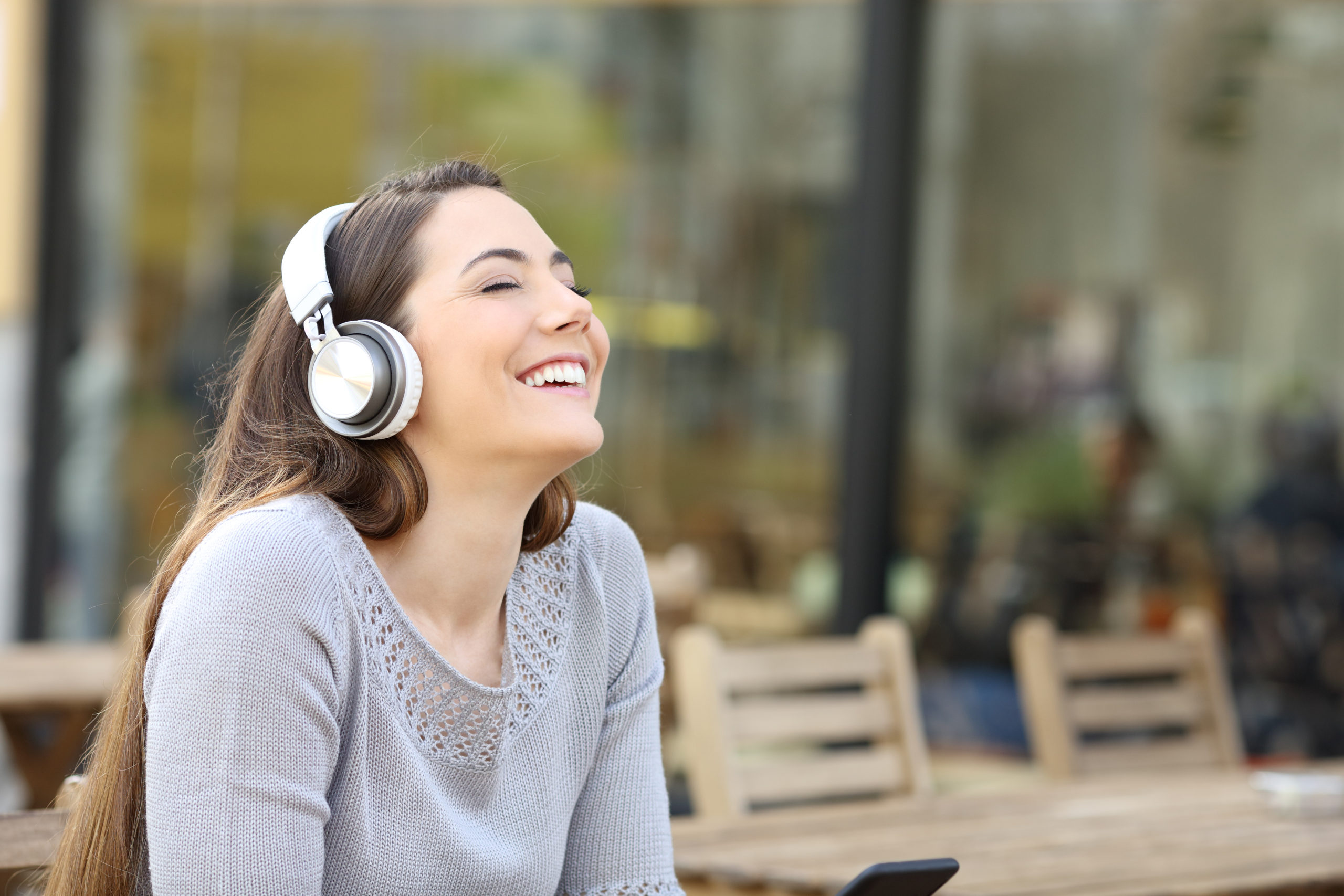 Happy,woman,breathing,fresh,air,listening,to,music,with,headphones