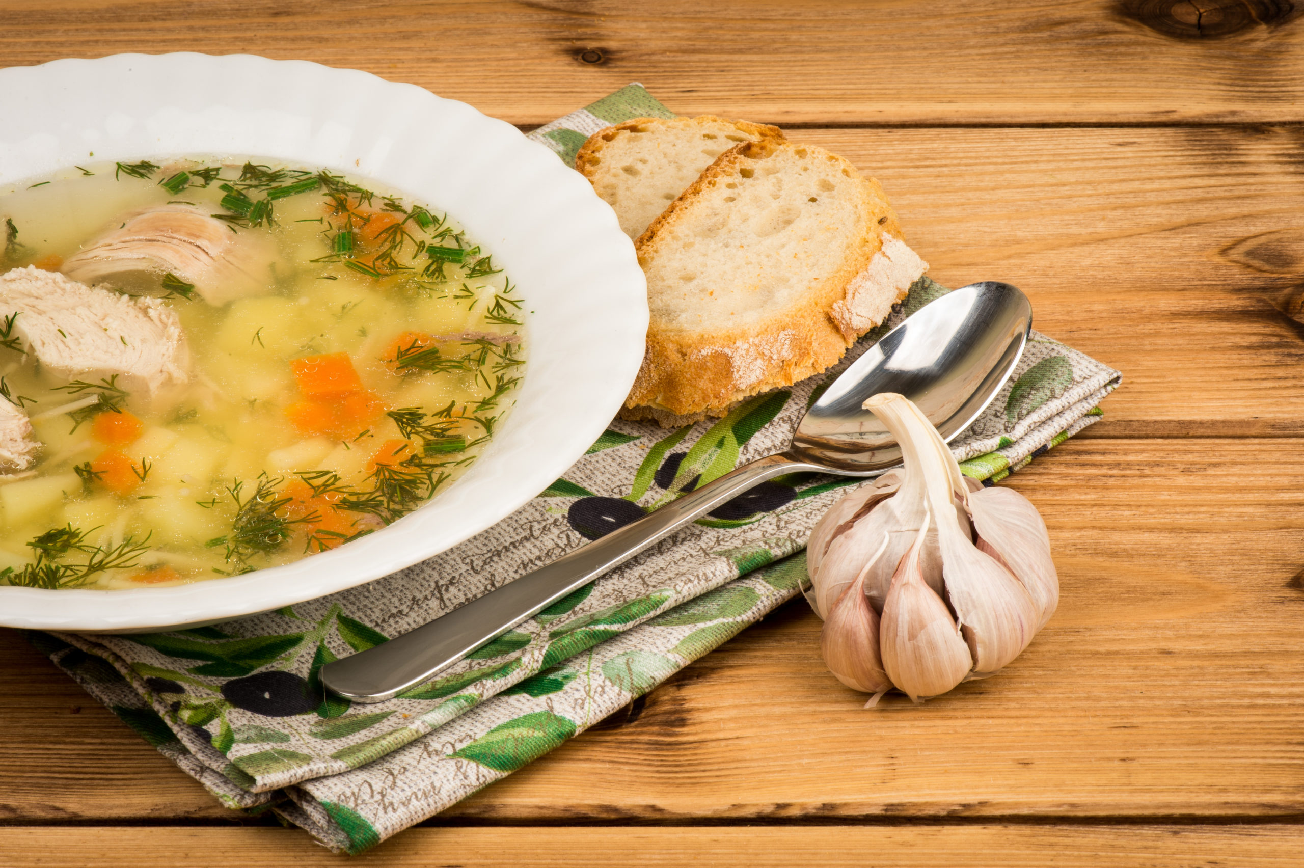Chicken,soup,with,a,bread,and,garlic,on,the,wooden