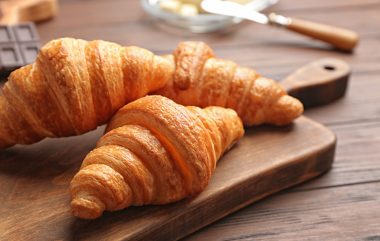 Board,with,tasty,croissants,on,wooden,table,,closeup.,french,pastry