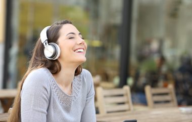 Happy,woman,breathing,fresh,air,listening,to,music,with,headphones