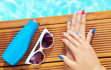 56915010 - woman lying down by the pool, marine sailor gel nails close up summer beauty concept